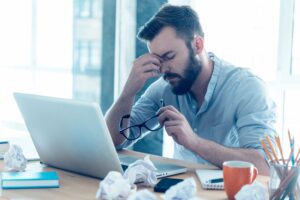 a stressed man with one hand on his head